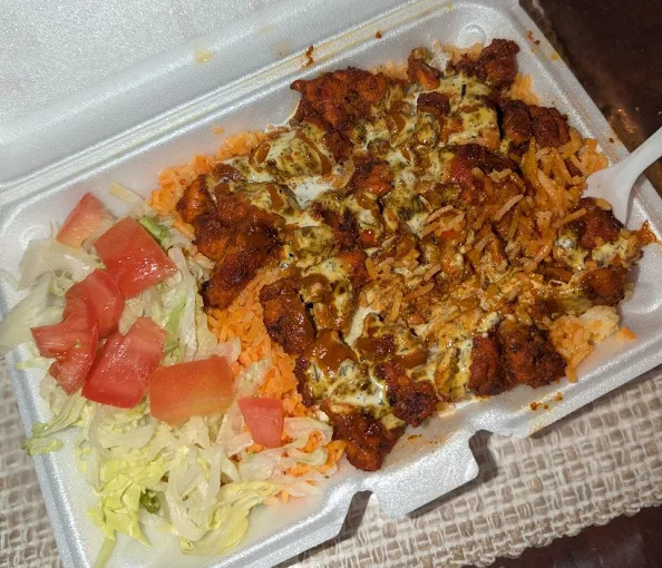 Munchies takeout bag with menu boards in the background
